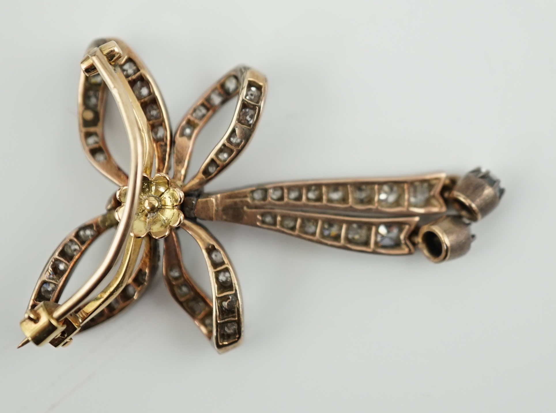 An Edwardian gold, silver and graduated diamond cluster set twin drop ribbon bow brooch